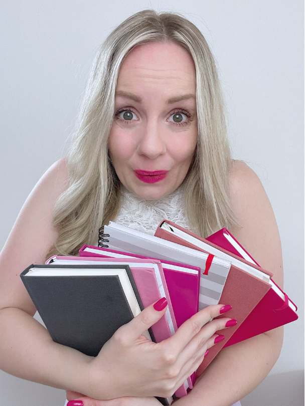 Inga mit einem Stapel Planer und Büchern